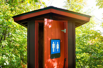 Gorgeous red and brown public toilet in the middle of the woods, Gatineau Park ,Quebec, Canada.