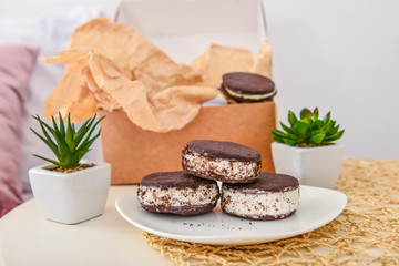 Plate with tasty ice cream cookie sandwiches on table