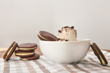 Bowl with tasty ice cream and chocolate cookies on table