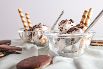 Bowl with tasty ice cream and chocolate cookies on table