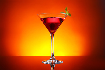 Glass of tasty cocktail on dark color background
