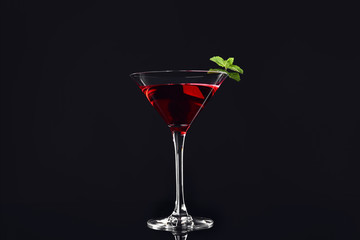 Glass of tasty cocktail on dark background