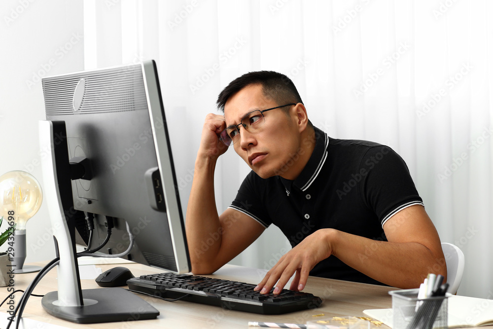 Poster asian programmer working on computer in office