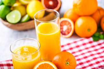 Clear two glasses of fresh pressed orange juice. Orange juice on table with half orange. Multivitamins