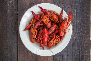 Boiled red crayfish on a wooden chopping Board. Black background, top view, close up