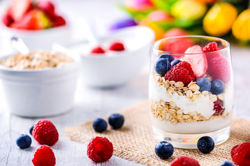 White yogurt with forest fruits. Raspberries and blueberies in clear glass with yogurt.