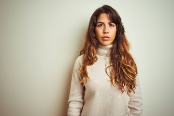 Young beautiful woman wearing winter sweater standing over white isolated background Relaxed with...