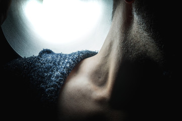 The neck of a man in the light.