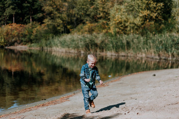 Portrait of cute smiling boy on a summer riverbank.