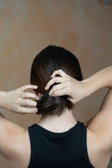 Naklejka premium Rear view of a lady arranging her hair