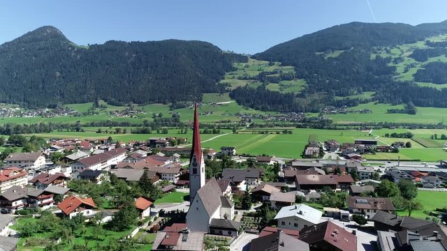 Aerial view moving towards Pfarrkirche located in Schlitters a small town in Zillertal valley in Austria near the strongly glaciated section of the Alps also most visited by tourists in the area 4k