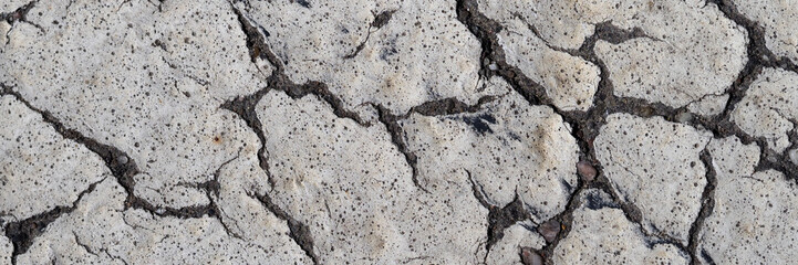 White paint over old cracked asphalt closeup background concept