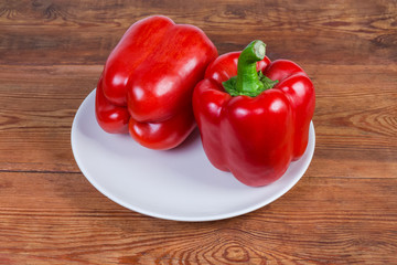 Red bell peppers on dish on the old rustic table