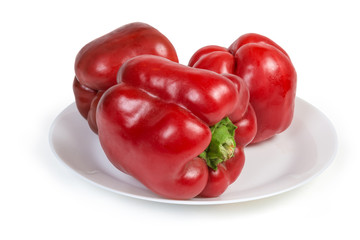 Red bell peppers on the dish on a white background