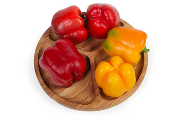 Red and yellow bell peppers on the wooden compartment dish