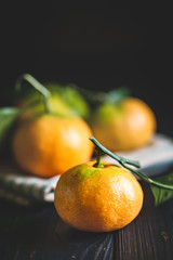 Tangerines with leaves on an old fashioned country table. Selective focus. Vertical.