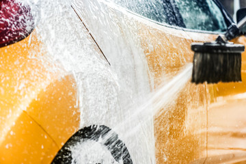 Car washing with soap and high pressure water.