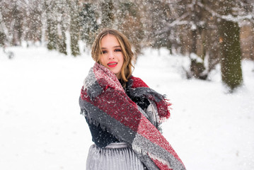 Christmas, New Year, winter holidays concept. Cute teenage girl with curly hair. playing with snow in park.