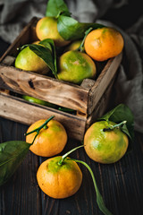 Tangerines with leaves on an old fashioned country table. Selective focus. Vertical.