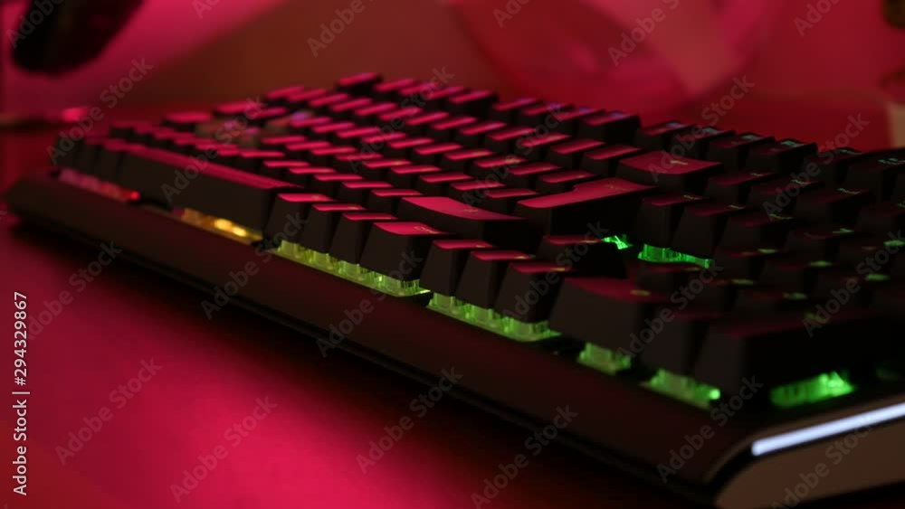 Aufkleber close up of a mechanical gaming keyboard with rgb lighting system set on rainbow effect. in the back