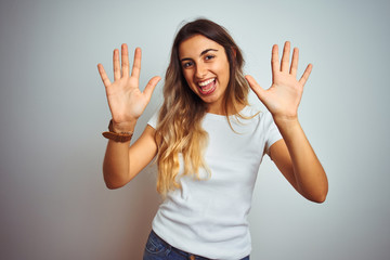 Young beautiful woman wearing casual white t-shirt over isolated background showing and pointing up...