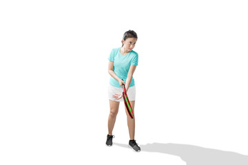Asian woman with a tennis racket and ball in her hands ready in serve position