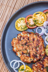 Chopped chicken cutlet with grilled vegetables lie on a plate. Grilled poultry and vegetables. Beautiful food. Food layout.