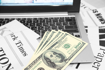 Newspapers, Laptop and Money in Cash. Business Magazines and Computer as Concept for Finance and...