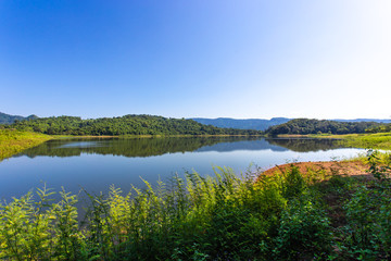 Fototapeta na wymiar Beautiful landscape view of mountains and trees at reservoir in Thailan