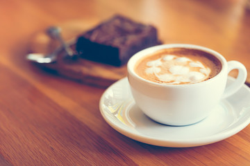 cup of coffee in a white cup on wooden background, coffee shop