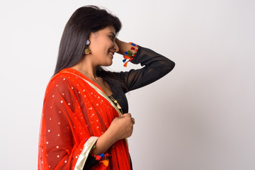 Profile view of happy young Persian woman smiling in traditional clothing
