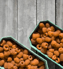 Fresh yellow raspberries in craft stalls, containers. on a wooden rustic old background. Top view of ripe berries. Autumn harvest.