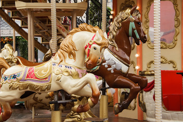 Fototapeta na wymiar Children's carousel with horses in an amusement park. Empty carousel on a clear sunny autumn day.
