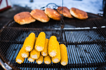 Organic Grilled Corn on the Cob Ready to Eat. Grilled corn with thai butter. Fried corncobs on a grid. Breaded cakes baked on the grill in winter.