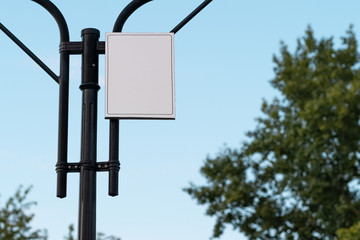 empty white signboard on a metal pole against the sky with a copy space for your text. blank white information sign , mock-up
