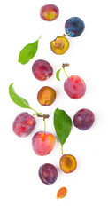 Ripe plums with leaves close up on white background