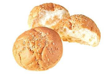 One whole and two halves of broken tasty soft fresh round bun with sesame seeds for cooking hamburger, cheeseburger or other burgers. Isolated on white background. Close-up