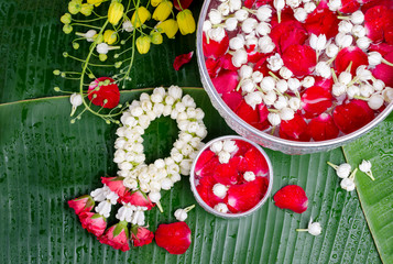 Jasmine and roses in silver bowl on leaves of banana background ,Songkran festival in Thailand
