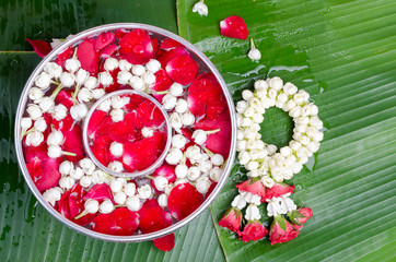 Jasmine and roses in silver bowl on leaves of banana background ,Songkran festival in Thailand
