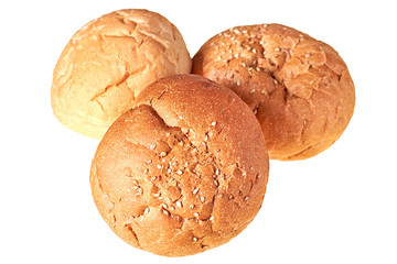 Three tasty soft fresh whole round buns with sesame seeds for hamburger, cheeseburger or cooking other burgers. Isolated on white background. Close-up