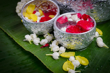 Jasmine and roses in silver bowl on leaves of banana background ,Songkran festival in Thailand