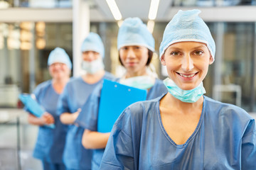 Smiling young surgeon in blue surgical clothing