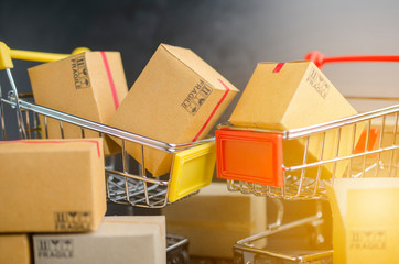 Many boxes in a trolley on a laptop keyboard,on brick background. Ideas online shopping is a form...
