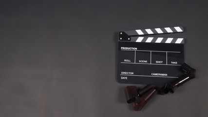 Clapperboard or clap board or movie slate with film use in video production ,film, cinema industry on black background.