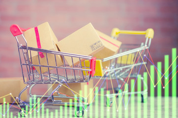 Paper boxes in a shopping cart on wood table,e-commerce or electronic commerce is a transaction of buying or selling goods or services online over the internet.