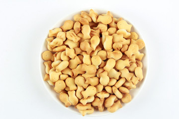 tasty cookies in the form of fish in a white saucer on a white background