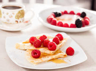 breakfast of pancakes with fresh raspberries on table
