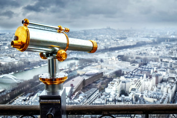 Big telescope for observation Paris town from eifel tower. Monocular telecope near steel fence.