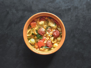 Spicy chorizo sausage stew with vegetables and greens, top view. 