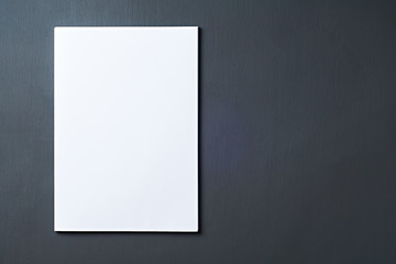 Single heap of blank white paper sheets lies on dark concrete table on workplace of secretary, director, boss or other worker of company. Space for text. Top view